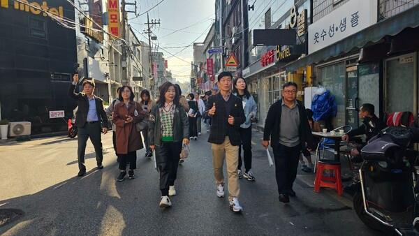 [사진: '신당10구역' 이창우 조합장이 원생들과 함께 걸으며 설명하고 있다. @한국도시환경헤럴드]